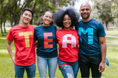 Group of four people wearing shirts that spell out team